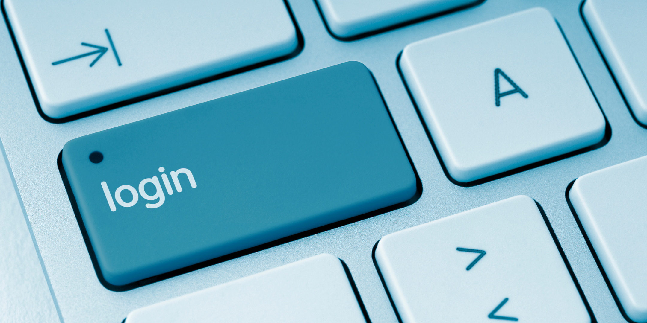 Close-up of a computer keyboard featuring a large blue key labelled “login.”